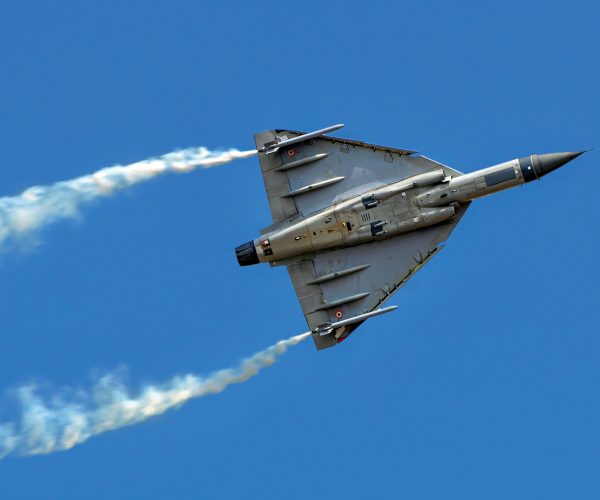 HAL Tejas of Indian Air Force performing aerobatic maneuver with smoke trails.